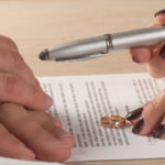 woman giving a pen to her spouse woman giving a pen to her spouse