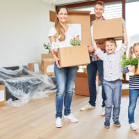 As a result of relocation, a family packs up boxes with children As a result of relocation, a family packs up boxes with children