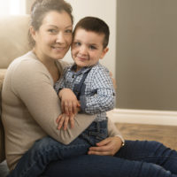mother with boy sitting on couch at home