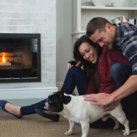 Couple relaxing with their pet dog in living room Couple relaxing with their pet dog in living room