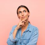 Young woman over isolated pink background thinking an idea