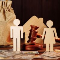 The division of property and divorce concept. Bag of money, house, people and the judge's hammer. The division of property and divorce concept. Bag of money, house, people and the judge's hammer.